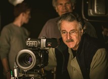 Faculty Member Dejan Georgevich looks into the viewfinder of a camera