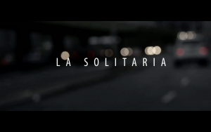 Poster for NElsons film shows an Out of focus view of a street with a car driving by and the title "La Solitaria" in the middle of the frame.