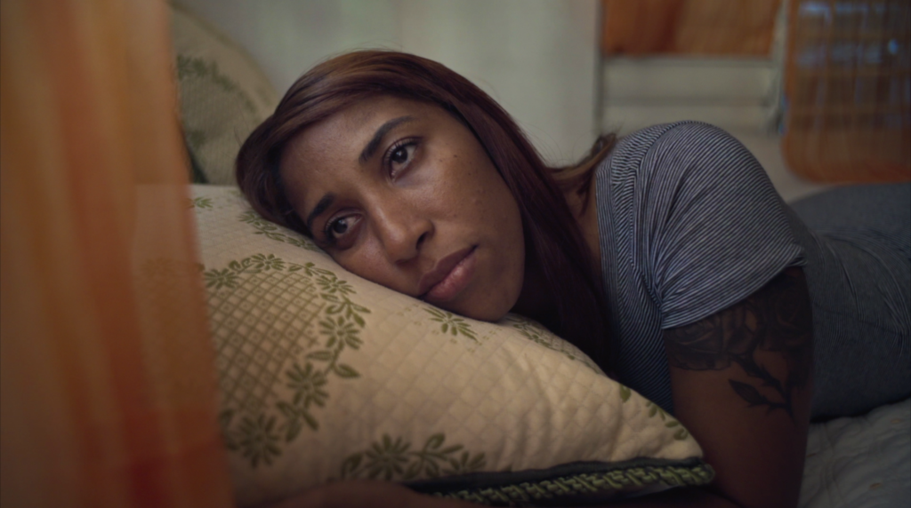 A close up of a person laying on a pillow with a mournful expression