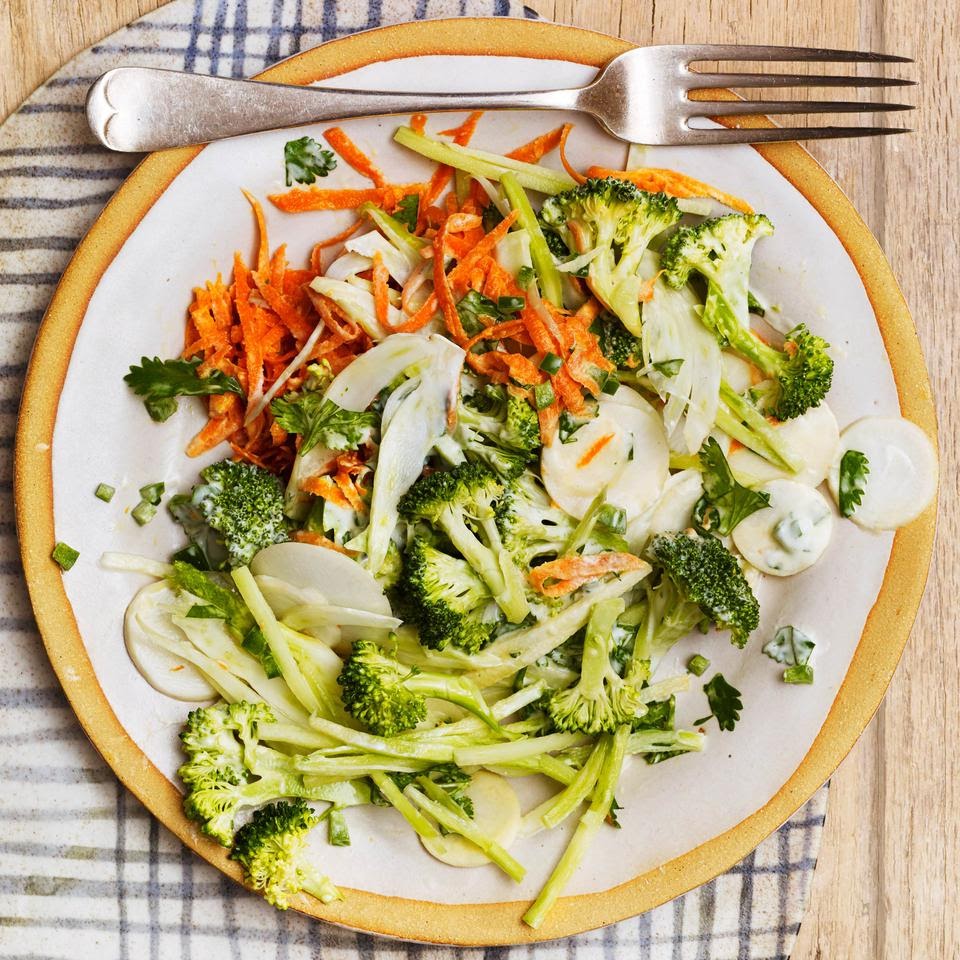 A plate of Borrocli, carrots, and other veggies with a fork next to it