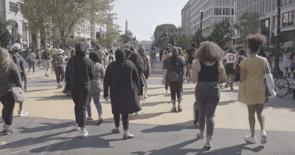 group of protestors march in solidarity singing chants and songs in solidarity for racial equality down Black Lives Matter Plaza in D.C.