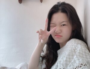 Selfie of Julie Jang winking at camera giving peace sign