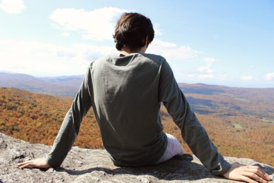 SVA student Silas Wisell sits on the edge of a cliff looking off into the distance