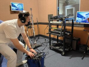 Kevin Fann inside a sound recording studio creating foley sounds for a project.