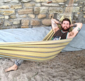 Oliver Slate-Greene lays in a hammock with a big smile.