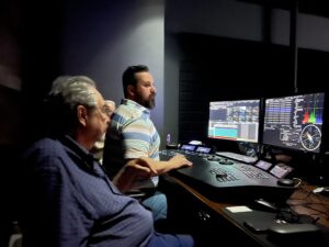 Three people gather around a computer color correcting program