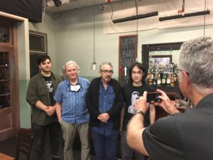 Image of several people gathered around for a photo in the SVA cafe set