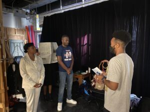 Mickel Cannon speaks with two people on the set of his film.