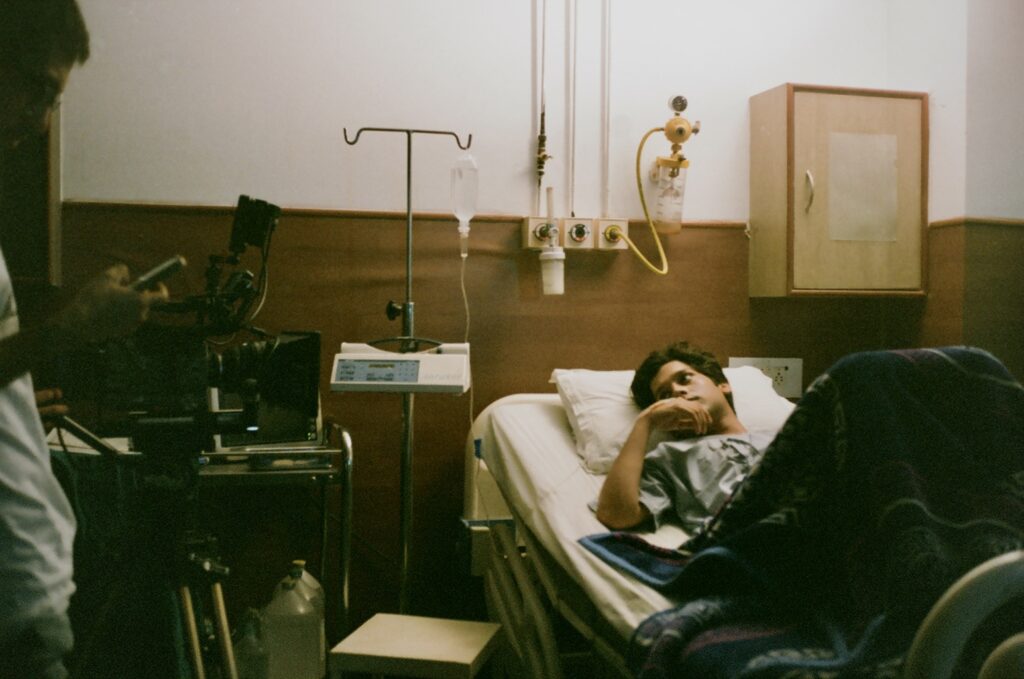 Behind the scenes still of Subah with the main character laying in bed.