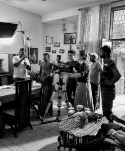 The crew of Subah set up a shot with a group of people surrounding a camera holding film equipment.
