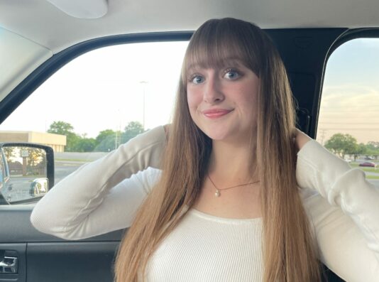 Profile photo of student Michelle Grace in the passenger seat of a car, wearing a white shirt.