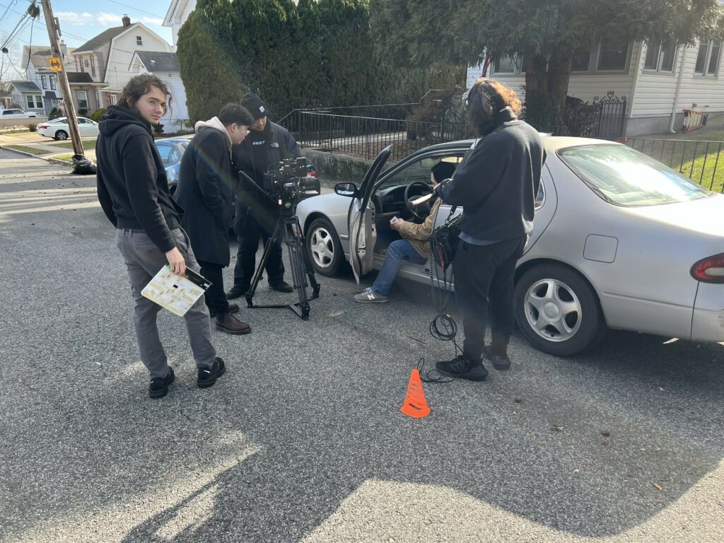 Film crew from Luis's shoot shooting a car scene with an actor in the front seat.