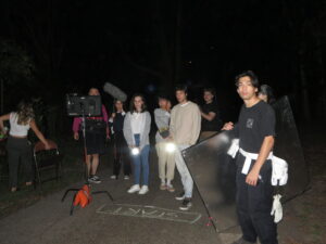 behind the scenes photo of roberts film crew gathered outside in the pitch black night.