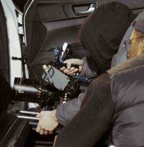 Behind the scenes photo from Khalil's film. Shows camera person working to figure out a shot inside a car.