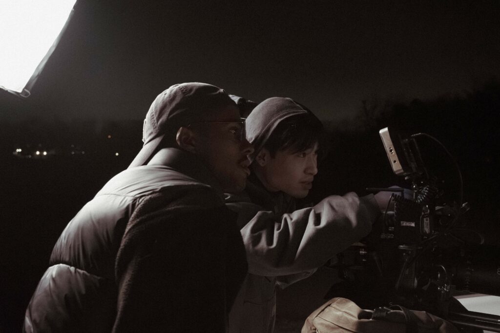 Behind the scenes photo from Khalil's film shows two people looking through a viewfinder.