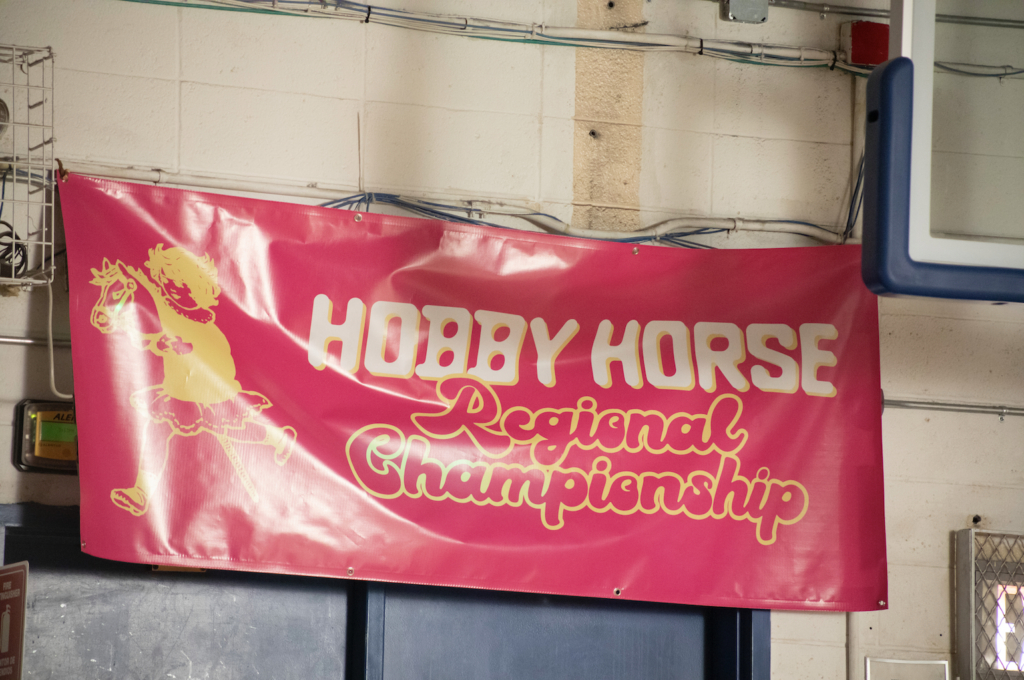 Screenshot from Hobby shows a banner in a gymnasium with the text "Hobby Horse Regional championship"