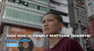 Still from the documentary Find Me, a woman in front of a building and next to a street sign with Chinese characters. She looks in the distance. Written across the picture, DOC NYC U: Family matters (short)