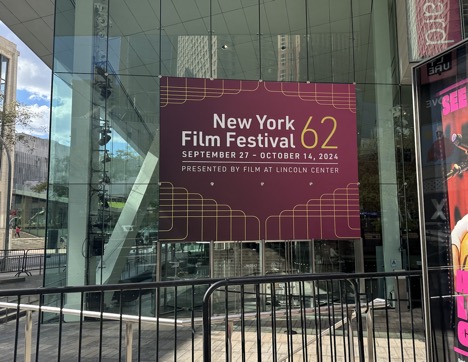 New York 62nd Film Festival poster hanging on the glass facade of the Alice Tully Theater. The poster information says that the festival happened from September 27nd through October 14th and it was presented by Film at Lincoln Center.