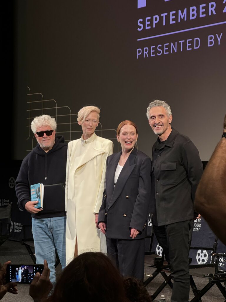 Photo of Pedro Almodóvar, Tilda Swinton, Julianne Moore, and John Turturro standing side by side. They are onstage for a Q&A at the 62nd New York Film Festival.