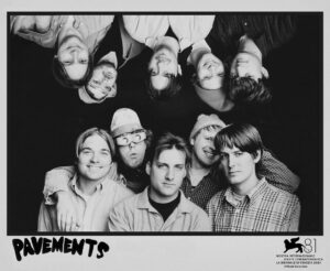 Poster for the film Pavements. A black and white photograph of the central cast comprises the majority of the poster, with the title and the Venice Film Festival Official Selection logo in the bottom margins.